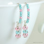 Sterling silver earrings with light pink and blue green Austrian crystal dangles and tiny crystals crusting the long hook ear wires handmade by Jessica Luu Jewelry