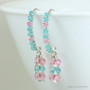 Sterling silver earrings with light pink and blue green Austrian crystal dangles and tiny crystals crusting the long hook ear wires handmade by Jessica Luu Jewelry