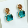 Two tone earrings with 8mm teal blue faceted cube shaped Austrian crystals and 6mm amber  brown faceted round Austrian crystals in 14K yellow gold filled wire wrapped setting handmade by Jessica Luu Jewelry
