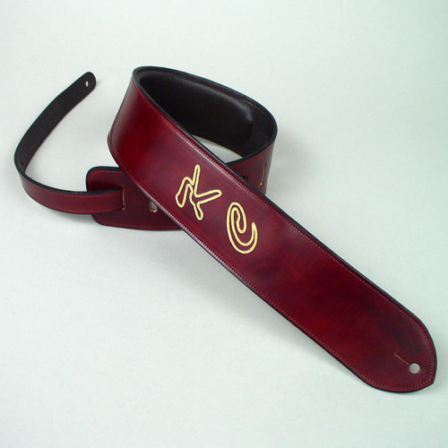 Large gold lettering is etched into this burgundy leather personalized guitar strap with  a foam padding.