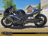 DME Aluminum Swingarm Suzuki GSXR1000 (01-02), black motorcycle rear swingarm with chrome chain and custom performance parts, set against suburban neighborhood background.