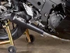 M4 Performance Exhausts M4 GP Black Exhaust Kawasaki ZX-14R (12-25), close-up of the black motorcycle exhaust with a skull logo and gold-colored rear stand.