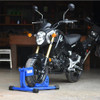 Baxley Scooter Chock, black scooter secured with a blue wheel chock in a garage setting.