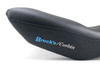 Brocks Performance Custom Corbin Seat BMW S1000RR (12-19) HP4 (12-15), close-up view of the black motorcycle seat with textured top and embroidered blue and white logo.