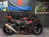 Akrapovic Exhaust Systems Akrapovic Racing GP Exhaust System Suzuki GSXR1000R (17-25), motorcycle with custom black and red color, parked indoors near Suzuki and Kawasaki posters.