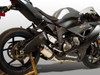 M4 Performance Exhausts M4 Street Slayer Titanium Exhaust Kawasaki ZX-6R (09-25), close-up of motorcycle with black and titanium exhaust system, rear wheel, and sleek aerodynamic body.