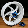 Coremoto Apex-6 Forged Aluminum Wheels Yamaha YZF-R1 (15-25), a white motorcycle wheel with a blue hub and a separate blue hub component placed on a wooden surface.
