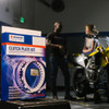 Suzuki OEM Complete Clutch Kit Suzuki GSXR750 (11-26), unopened clutch plate kit box displayed indoors with the motorcycle in the background.