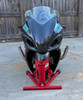 DME Racing Motorcycle Parts DME Zoomie Exhaust System on a motorcycle, close-up view of the aerodynamic carbon fiber fairing and dual exhaust pipes.