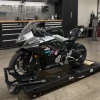 Brock’s Performance Motorcycle Parts Brocks Front End Lowering Strap Kit CFMOTO 675SS (25-26), motorcycle placed on a lift in a workshop environment.