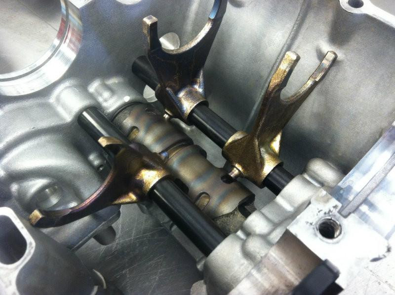 Suzuki OEM Shift Fork Small Suzuki GSX1300R Hayabusa (99-26), close-up of the shift fork components inside the engine casing showing metallic and black parts.