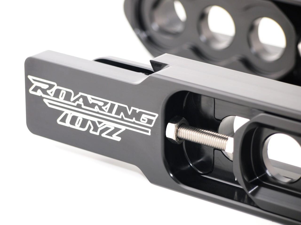 Roaring Toyz Bolt-On Swingarm Extensions Kawasaki ZX14R (06-26), close-up of the black metallic extension with white logo and bolt mechanism for motorcycle modification. Roaring Toyz Bolt-On Swingarm Extensions Kawasaki ZX14R (06-26), close-up of the black metallic extension with white logo and bolt mechanism for motorcycle modification.