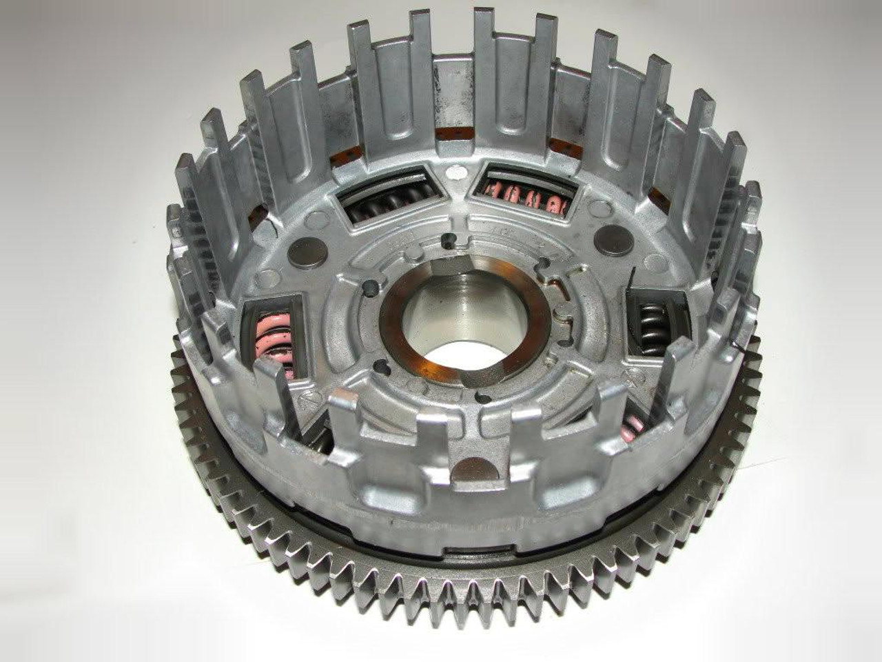 Kawasaki OEM Clutch Basket Kawasaki ZX14 (06-07), image showing a metallic clutch basket with visible springs and gear teeth. Kawasaki OEM Clutch Basket Kawasaki ZX14 (06-07), image showing a metallic clutch basket with visible springs and gear teeth.