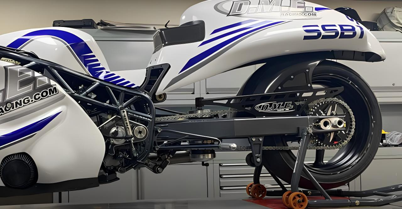 DME Aluminum Swingarm Suzuki Hayabusa (08-21), close-up of the black aluminum swingarm attached to a motorcycle with blue and white bodywork, showing detailed construction and chain drive system.
