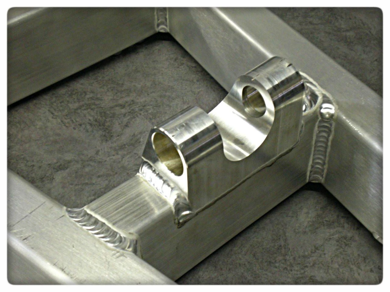 DME Aluminum Swingarm Kawasaki ZX14R (12-25), close-up of the polished silver swingarm component with welded joints for motorcycle upgrade.