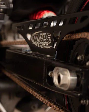 DME Aluminum Swingarm Kawasaki ZX12 (00-05), close-up of the black lightweight swingarm with DME logo, chain and sprocket attached.