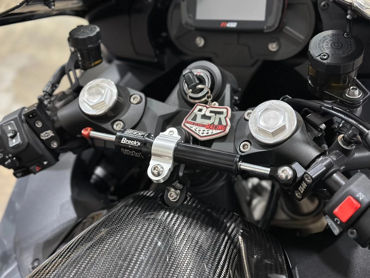 Brocks Performance Brocks Bitubo Steering Damper Kit Kawasaki ZX14R (06-25) Black, mounted on motorcycle handlebars with black and silver components, enhancing stability and handling.