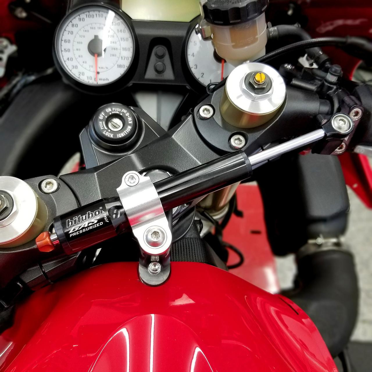 Brocks Performance Brocks Bitubo Steering Damper Kit Kawasaki ZX14R (06-25) Black, close-up view of the black and gold steering damper installed on a red Kawasaki ZX14R motorcycle with visible dashboard and handlebar components.