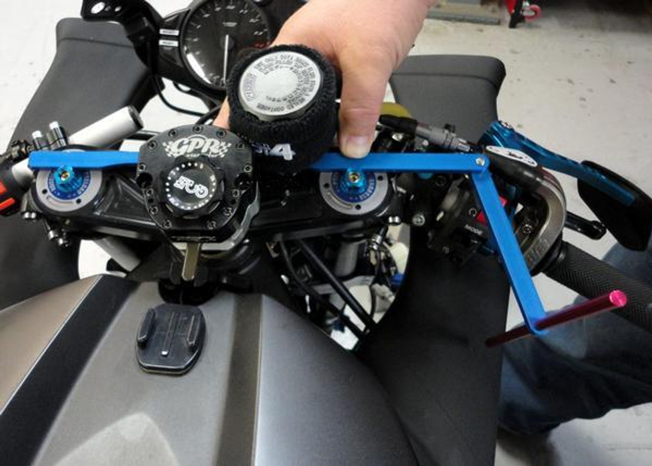 Motion Pro Clip On Handlebar Alignment Tool, close-up view being used on a motorcycle's handlebars for precise alignment adjustment. Motion Pro Clip On Handlebar Alignment Tool, close-up view being used on a motorcycle's handlebars for precise alignment adjustment.