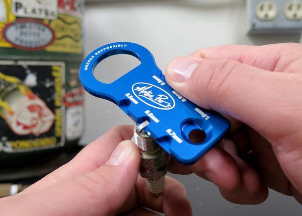 Motion Pro Spark Plug Gap Adjust Tool, blue aluminum spark plug gap tool being used to adjust a spark plug.
