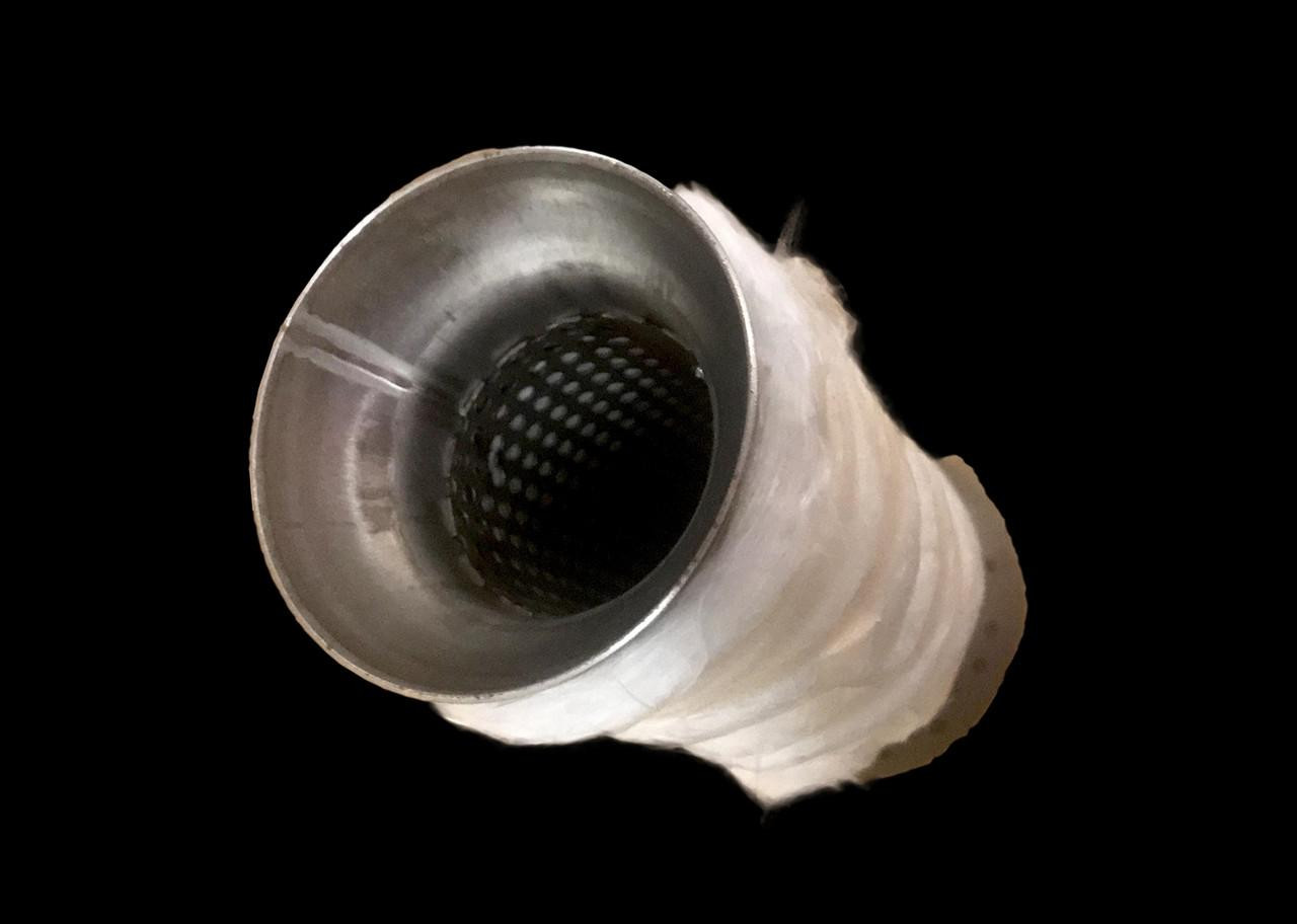 VooDoo Speakeasy Exhaust Insert, close-up view of a metallic vehicle exhaust insert with perforated interior design on a black background.