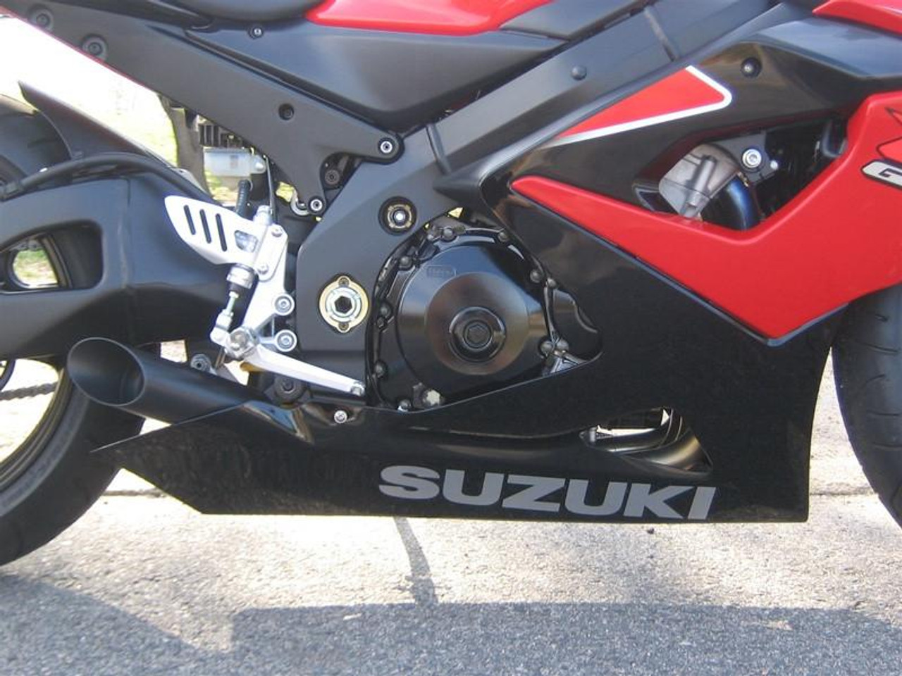 VooDoo Shorty Slip On Exhaust Suzuki GSXR1000 (05-06), close-up of motorcycle's black and red body with exhaust system and Suzuki branding on the lower fairing.