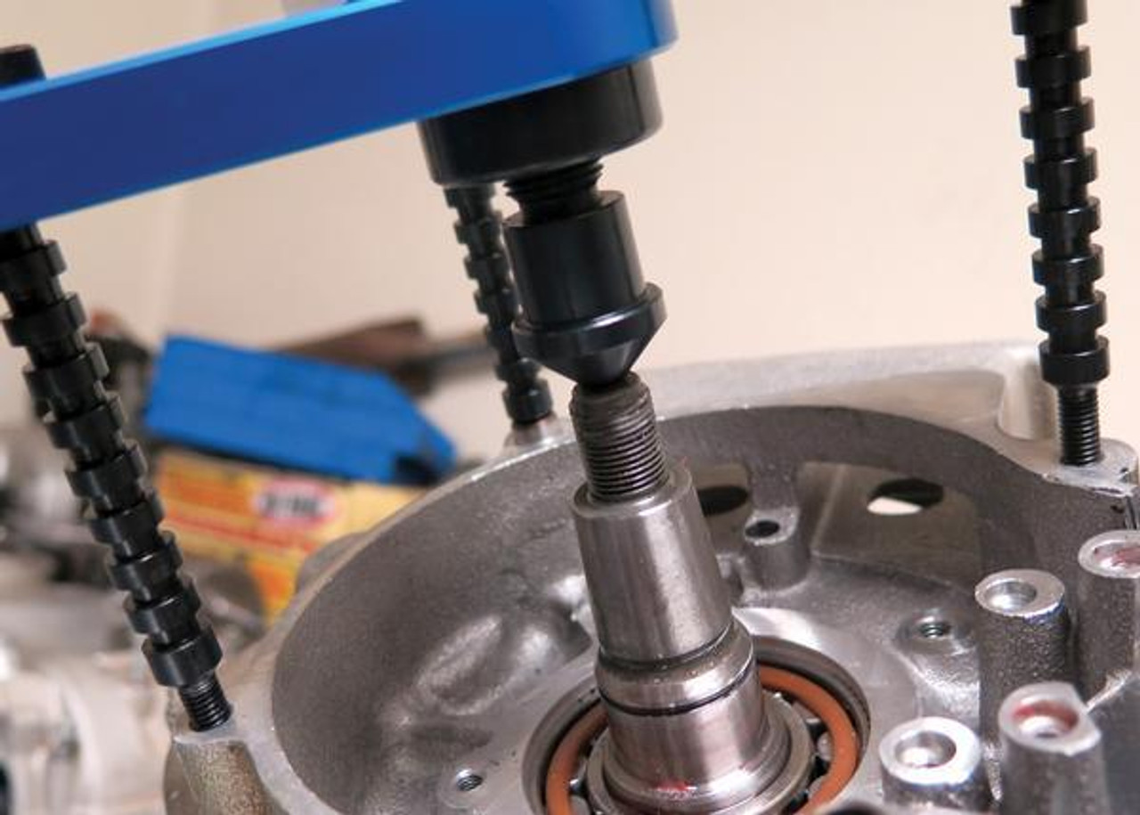 Motion Pro Crankcase Splitter V2, close-up view of the tool used for splitting motorcycle or engine crankcases with a black and blue design and a metal crankshaft inside the engine casing. Motion Pro Crankcase Splitter V2, close-up view of the tool used for splitting motorcycle or engine crankcases with a black and blue design and a metal crankshaft inside the engine casing.