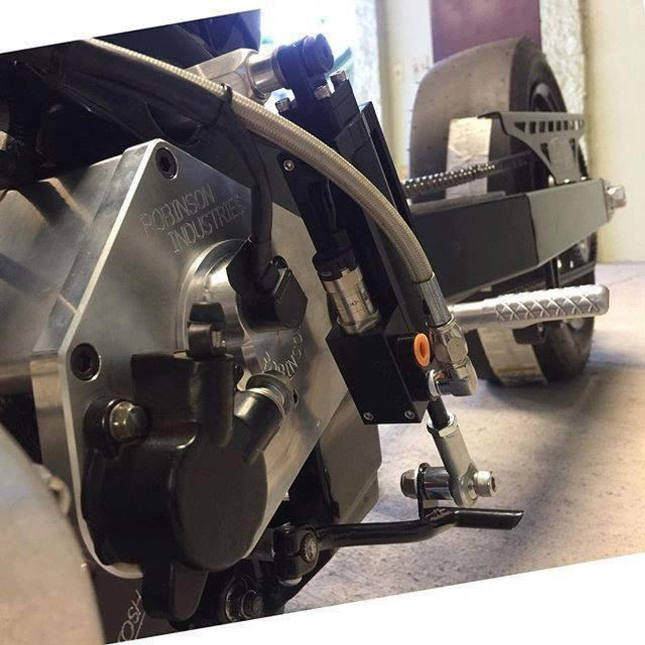 Ryan Schnitz Racing RSR Direct Shift Air Cylinder Assembly, close-up view of the high-performance racing gear component with metallic and black parts, attached to a motorcycle or racing vehicle.