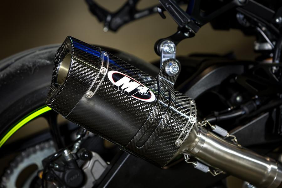 M4 Performance Exhausts M4 Tech1 Carbon Exhaust Suzuki GSXR1000 (17-27) All Titanium, close-up of the high-performance carbon fiber exhaust system installed on a motorcycle with visible titanium components and detailed engineering.