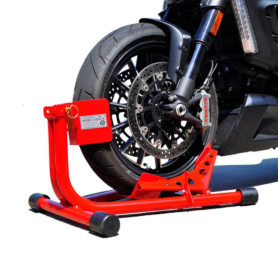 Baxley Sport Chock, motorcycle wheel chock with a red stand holding a motorcycle front wheel securely for maintenance or storage.