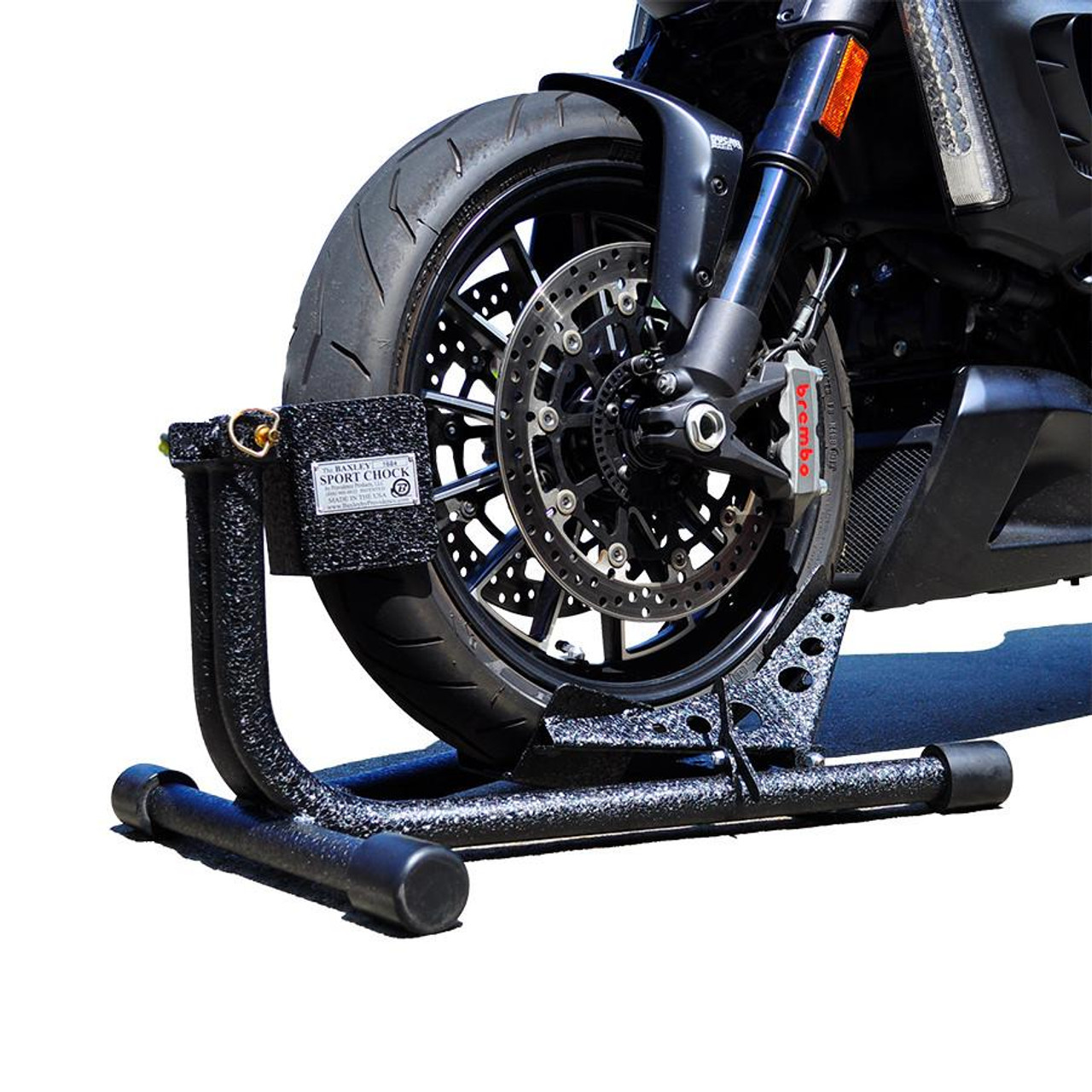 Baxley Sport Chock, metal motorcycle wheel chock with a textured black finish, supporting a motorcycle front wheel for stability and safety.