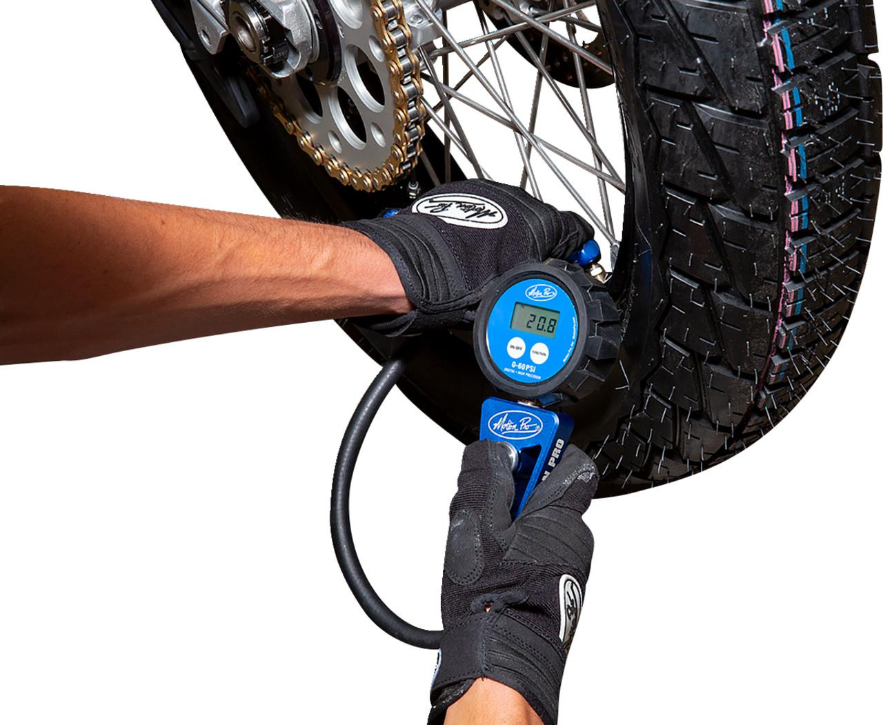 Motion Pro Digital Tire Pressure Gauge 0-60 psi, hand using the digital tire pressure gauge to measure pressure on a motorcycle tire.