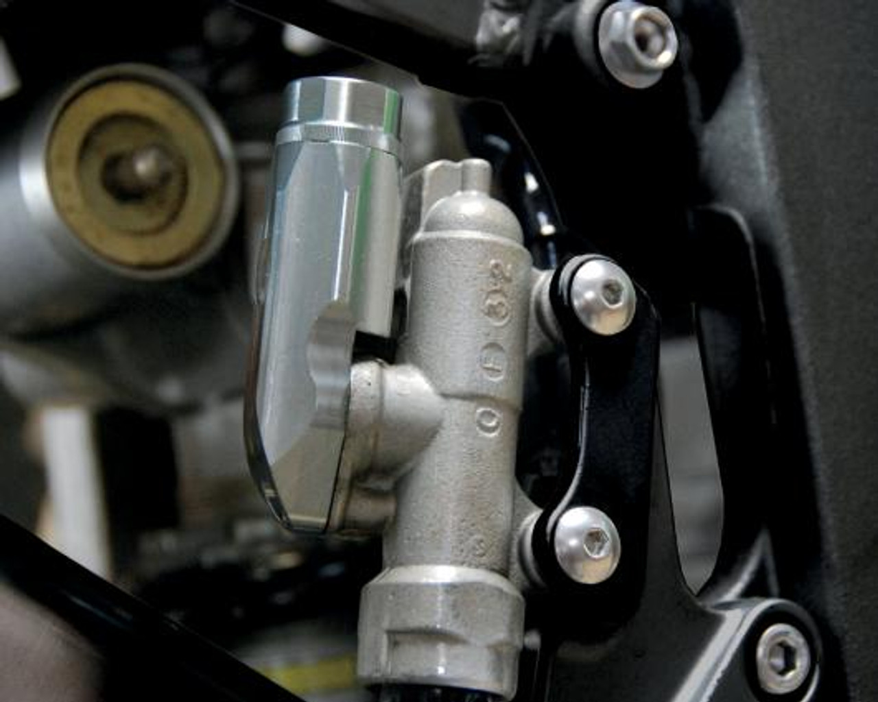 PSR Rear Brake Reservoir, close-up view of motorcycle rear brake fluid reservoir and mounting bracket.