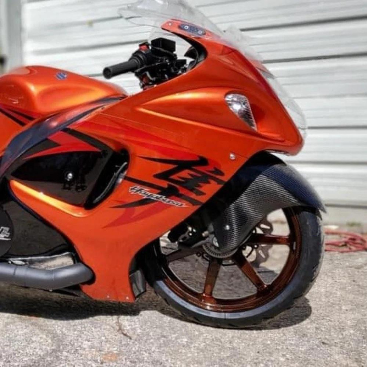 Montgomery Motorsports Carbon Fiber Aero Front Fender Suzuki Hayabusa (99-21), orange motorcycle with carbon fiber front fender and aerodynamic design. Montgomery Motorsports Carbon Fiber Aero Front Fender Suzuki Hayabusa (99-21), orange motorcycle with carbon fiber front fender and aerodynamic design.