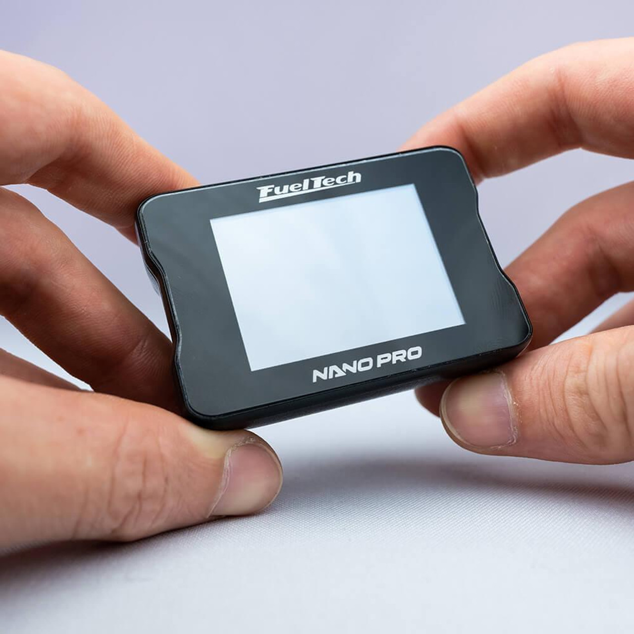 Fueltech NanoPRO, compact digital tuning device held between two hands. Fueltech NanoPRO, compact digital tuning device held between two hands.