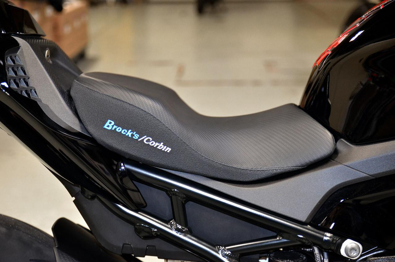 Brocks Performance Custom Corbin Seat for BMW S1000RR 2020-2025 and S1000R 2020-2024, close-up view of the sleek black seat with textured surface and illuminated logo.