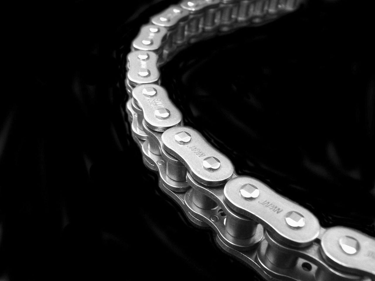 EK Chain 530 ZVX-3 X-Ring, close-up of a silver motorcycle chain with X-Ring design against a black background.