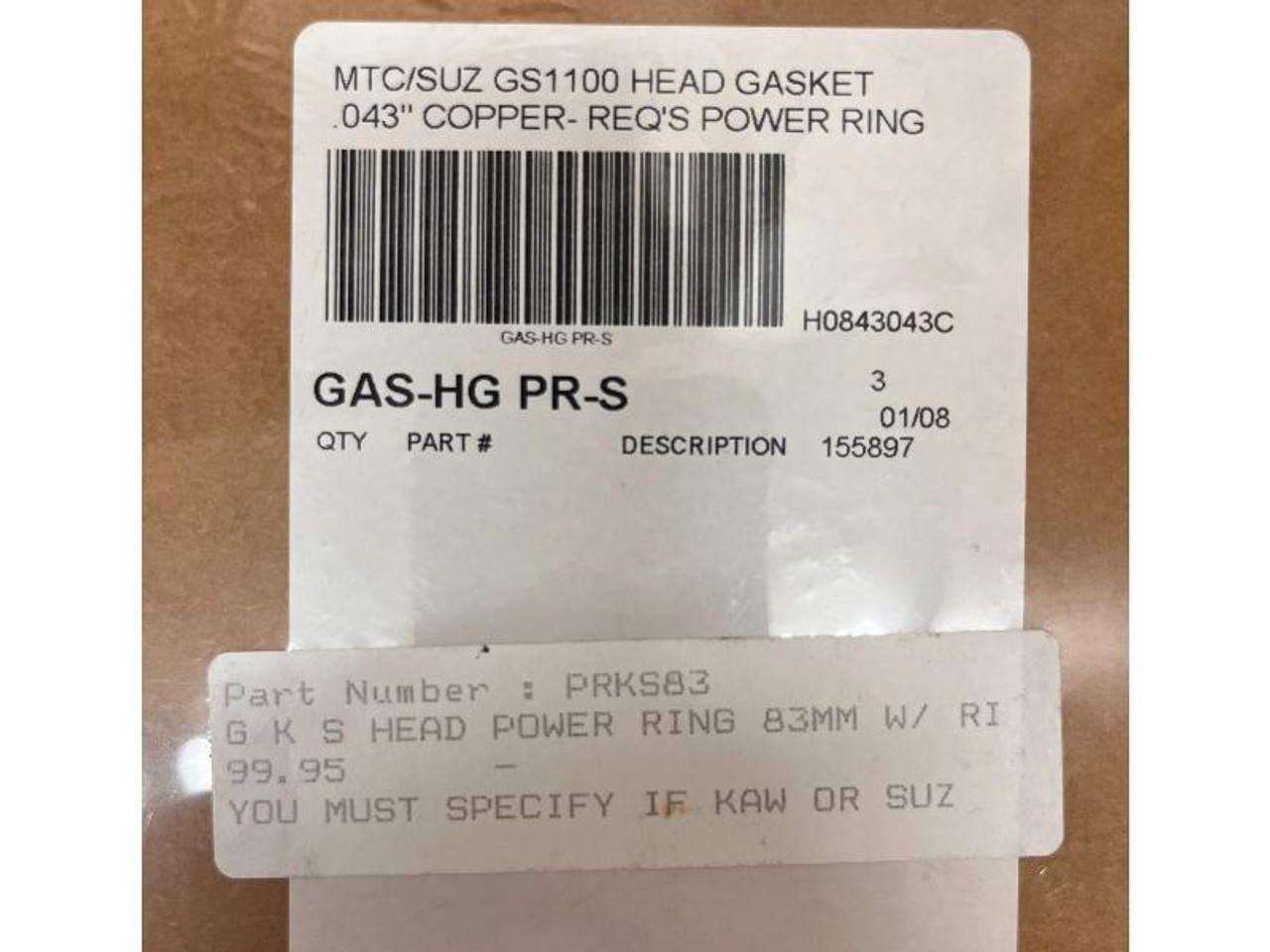 Product Cometic Head Gasket Suzuki GS1100, close-up of a label indicating it's a head gasket for Suzuki GS1100 motorcycle with specifications and part details.
