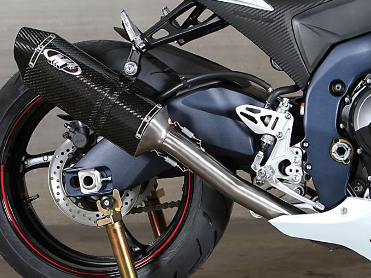 M4 Performance Exhausts M4 Tech1 Carbon Exhaust Suzuki GSXR1000 (12-16), close-up of the high-performance carbon fiber exhaust installed on a sport motorcycle.