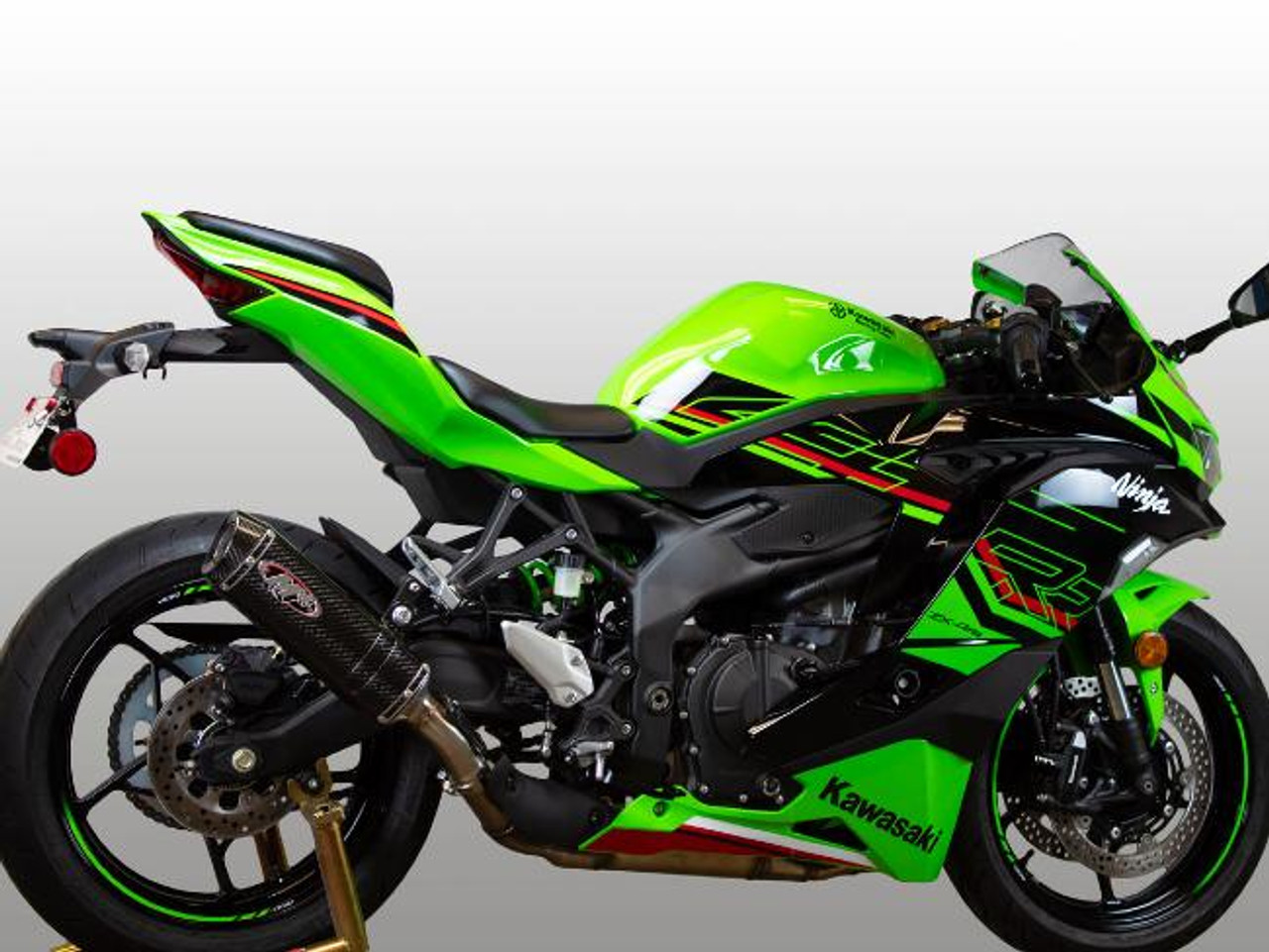 M4 Performance Exhausts M4 X-96 Carbon Fiber Slip On Exhaust Kawasaki ZX-4RR (23-25), a vibrant green Kawasaki ZX-4RR motorcycle with M4 X-96 carbon fiber slip-on exhaust installed for enhanced performance.