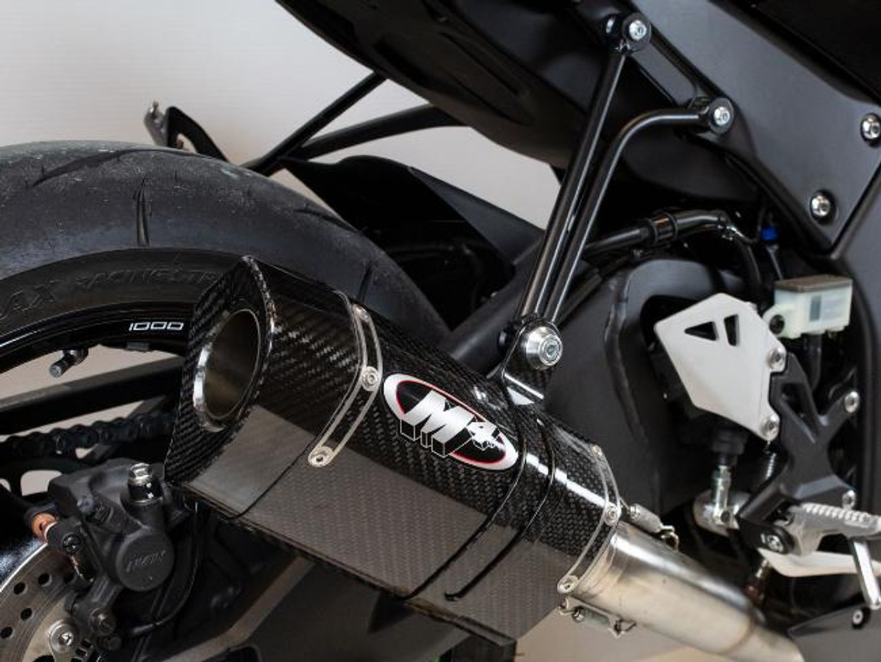 M4 Performance Exhausts M4 Tech1 Carbon Exhaust Kawasaki ZX-10R (16-25), close-up of a high-performance carbon fiber exhaust system installed on a Kawasaki ZX-10R motorcycle.