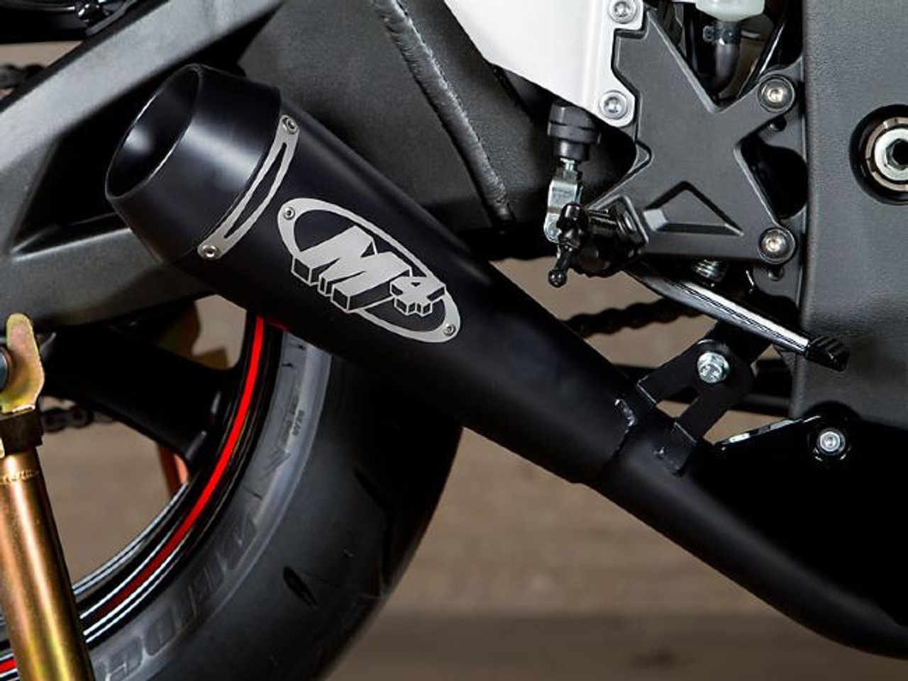 M4 Performance Exhausts M4 GP Black Slip On Exhaust Kawasaki ZX-10R (11-15), close-up view of the black exhaust pipe with the M4 logo mounted on a motorcycle.