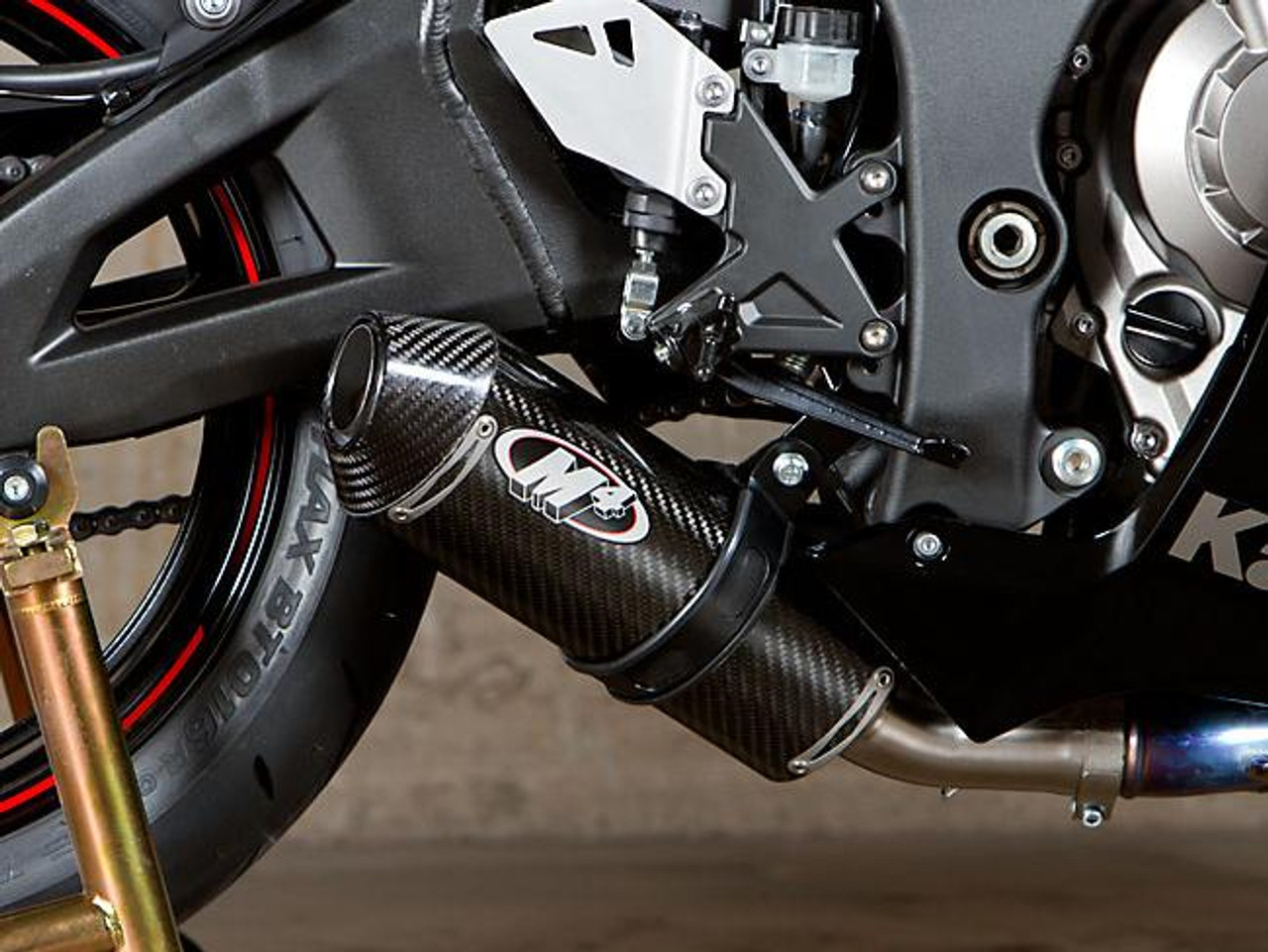 M4 Performance Exhausts M4 Street Slayer Carbon Slip On Exhaust Kawasaki ZX-10 (11-15), close-up of the high-performance carbon fiber muffler installed on a motorcycle with a detailed view of the exhaust and motorcycle components.