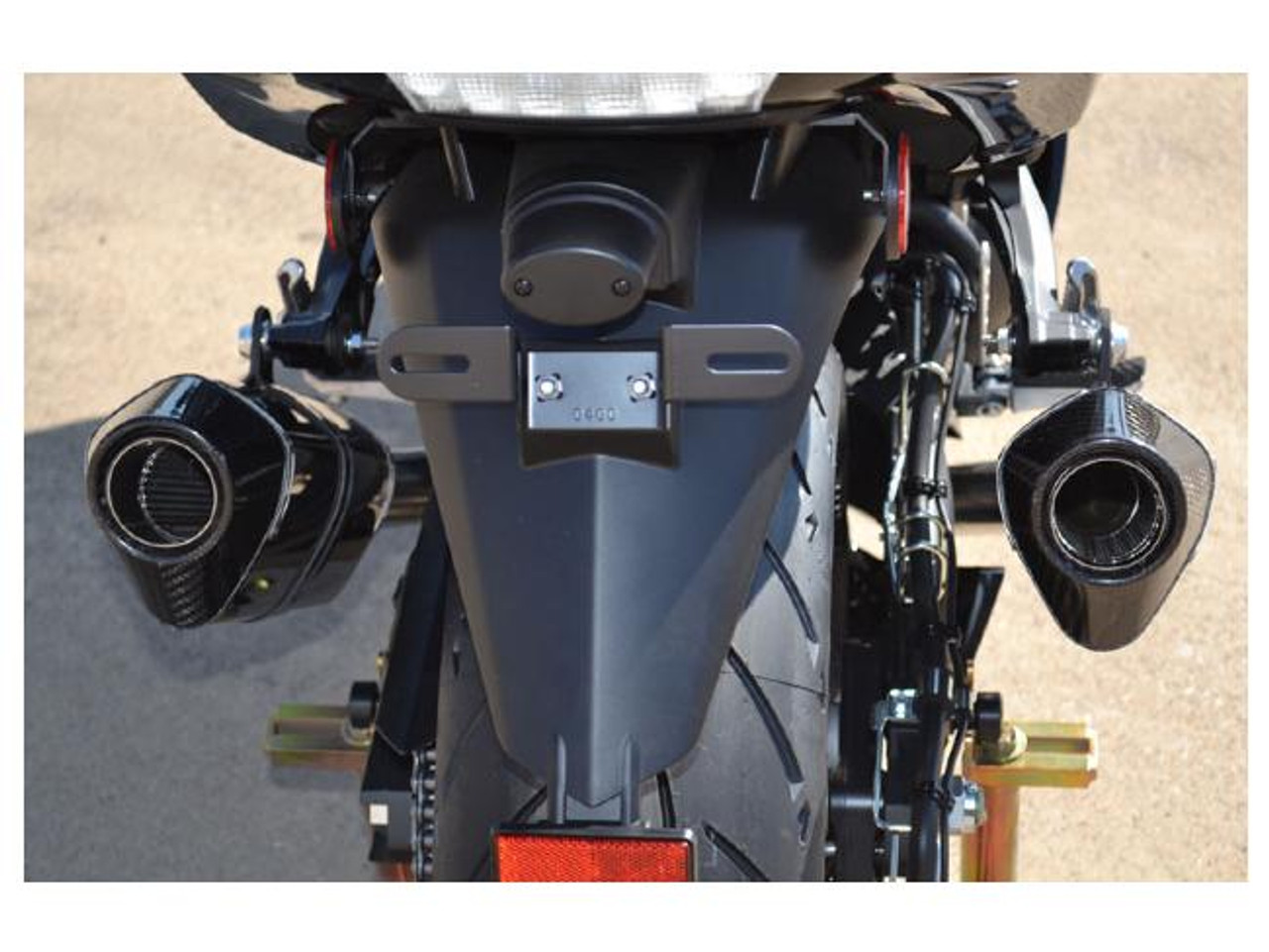 M4 Performance Exhausts M4 MC36 Carbon Fiber Slip On Kawasaki ZX-14 (12-26), close-up of motorcycle's rear showcasing carbon fiber slip-on exhausts on each side of the rear wheel.