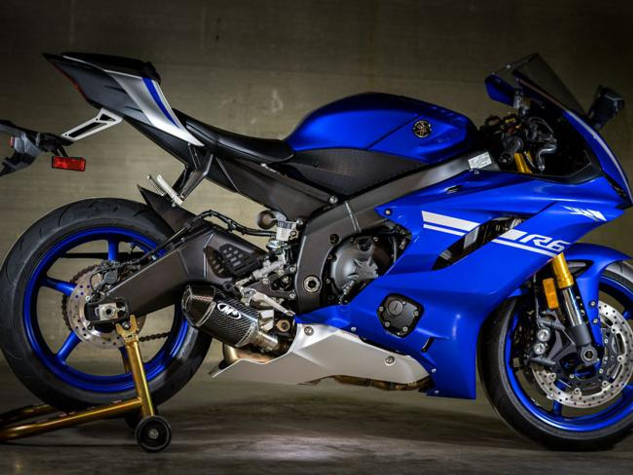 M4 Performance Exhausts M4 Carbon Fiber Street Slayer Slip On Yamaha YZF-R6 (06-20), side view of a blue racing motorcycle with custom exhaust system and aerodynamic design.
