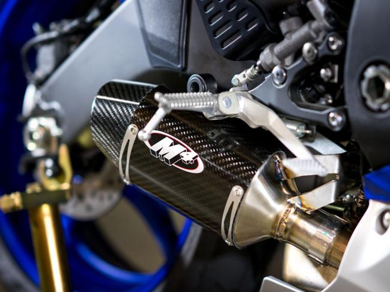 M4 Performance Exhausts M4 Carbon Fiber Street Slayer Slip On Yamaha YZF-R6 (06-20), close-up of motorcycle exhaust system showing carbon fiber slip-on muffler with M4 logo and metallic components.