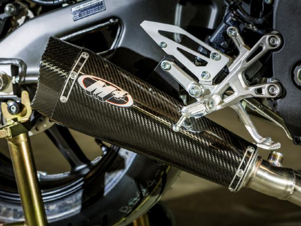 M4 Performance Exhausts M4 Carbon Fiber X-Model Slip On Exhaust Yamaha FZ-10/MT-10 (17-24), close-up of the high-performance carbon fiber motorcycle exhaust with the M4 logo, mounted on a Yamaha FZ-10/MT-10 motorcycle.