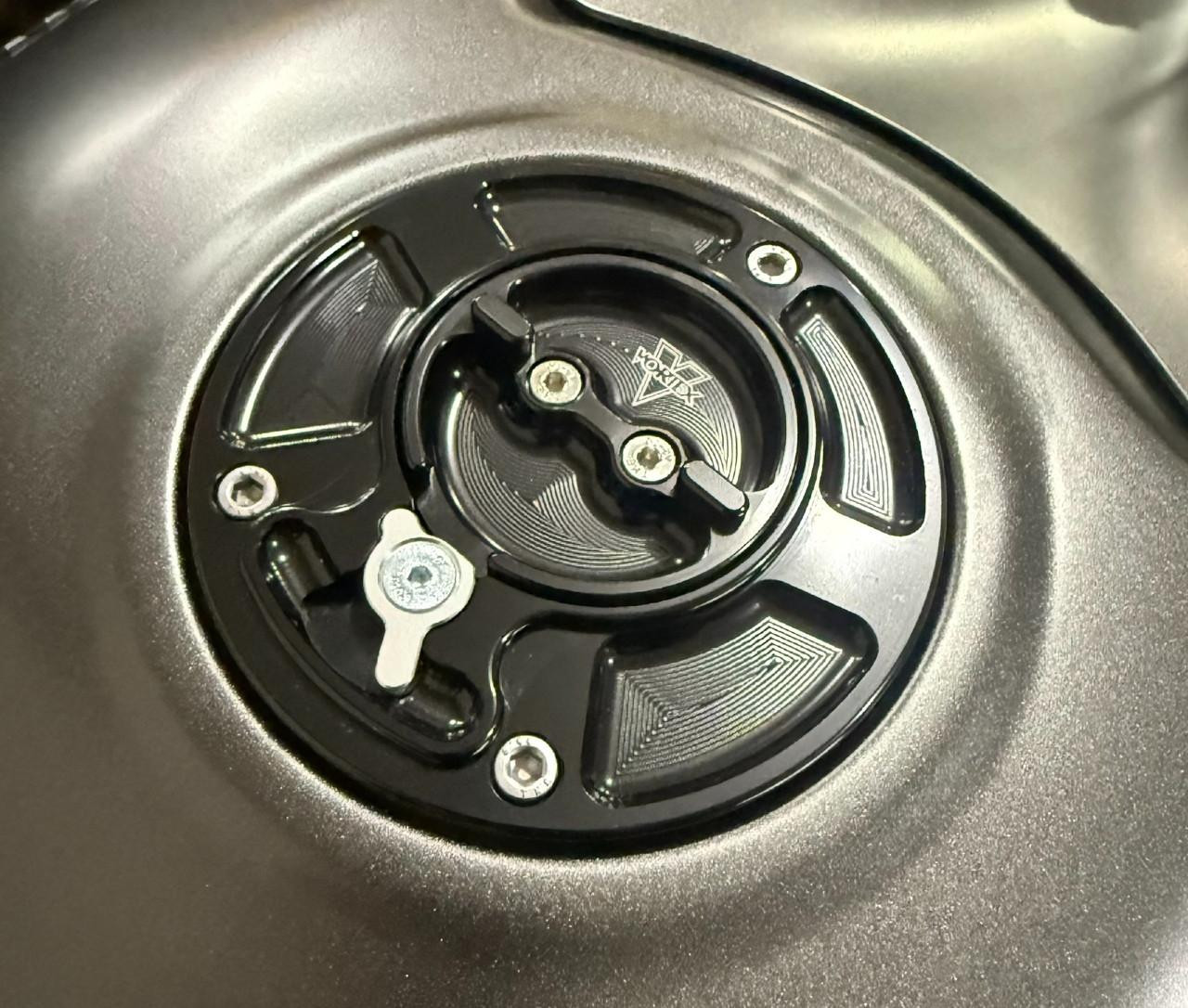 Vortex Gas Caps, close-up image of a black and silver vortex gas cap with intricate design and branding.