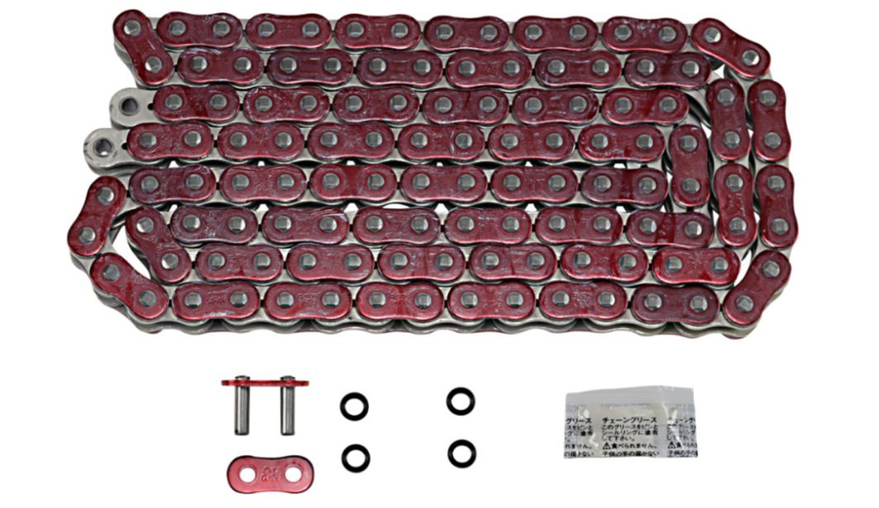EK Chain 525 ZVX-3 X-Ring, a red and silver motorcycle chain with black rubber O-rings, alongside chain link pins, O-rings, and a small packet of lubrication or maintenance grease.