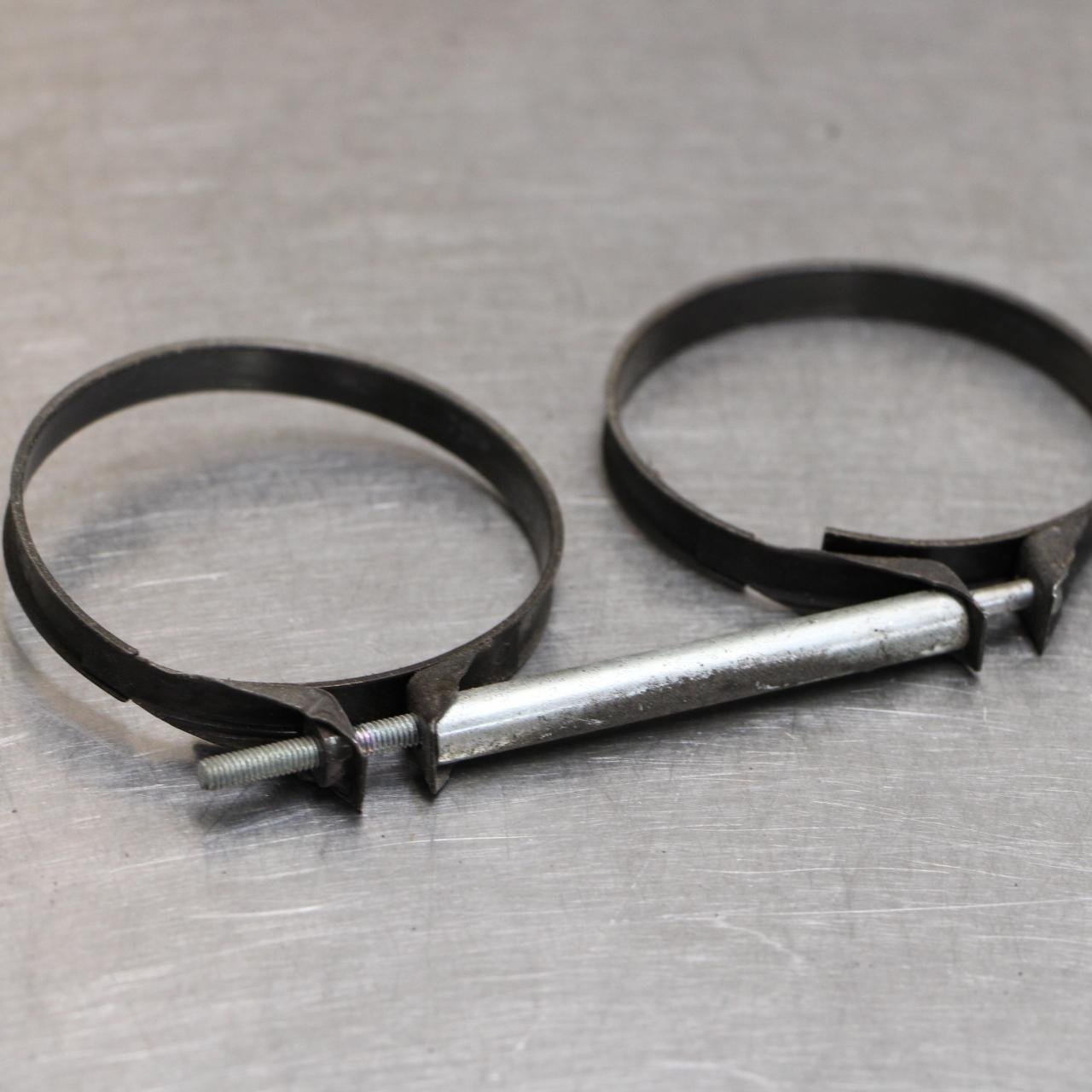 Suzuki OEM OEM Intake Pipe Clamps for Suzuki Hayabusa (99-07), image of black metal clamps connected by a metal bolt and threaded rod.